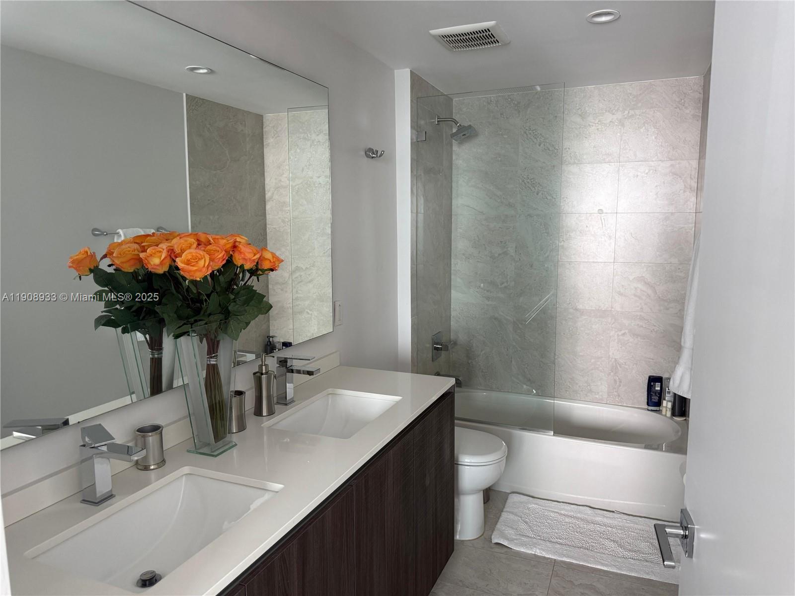 488 Northeast 18th Street, Unit 2701 Miami, FL 33132 - Photo 16 of 70 a bathroom with a sink a toilet and shower