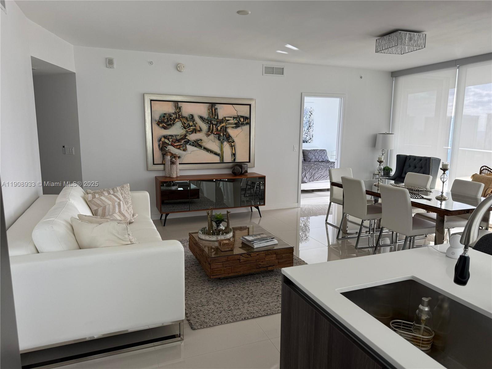 488 Northeast 18th Street, Unit 2701 Miami, FL 33132 - Photo 5 of 70 a living room with furniture and a flat screen tv