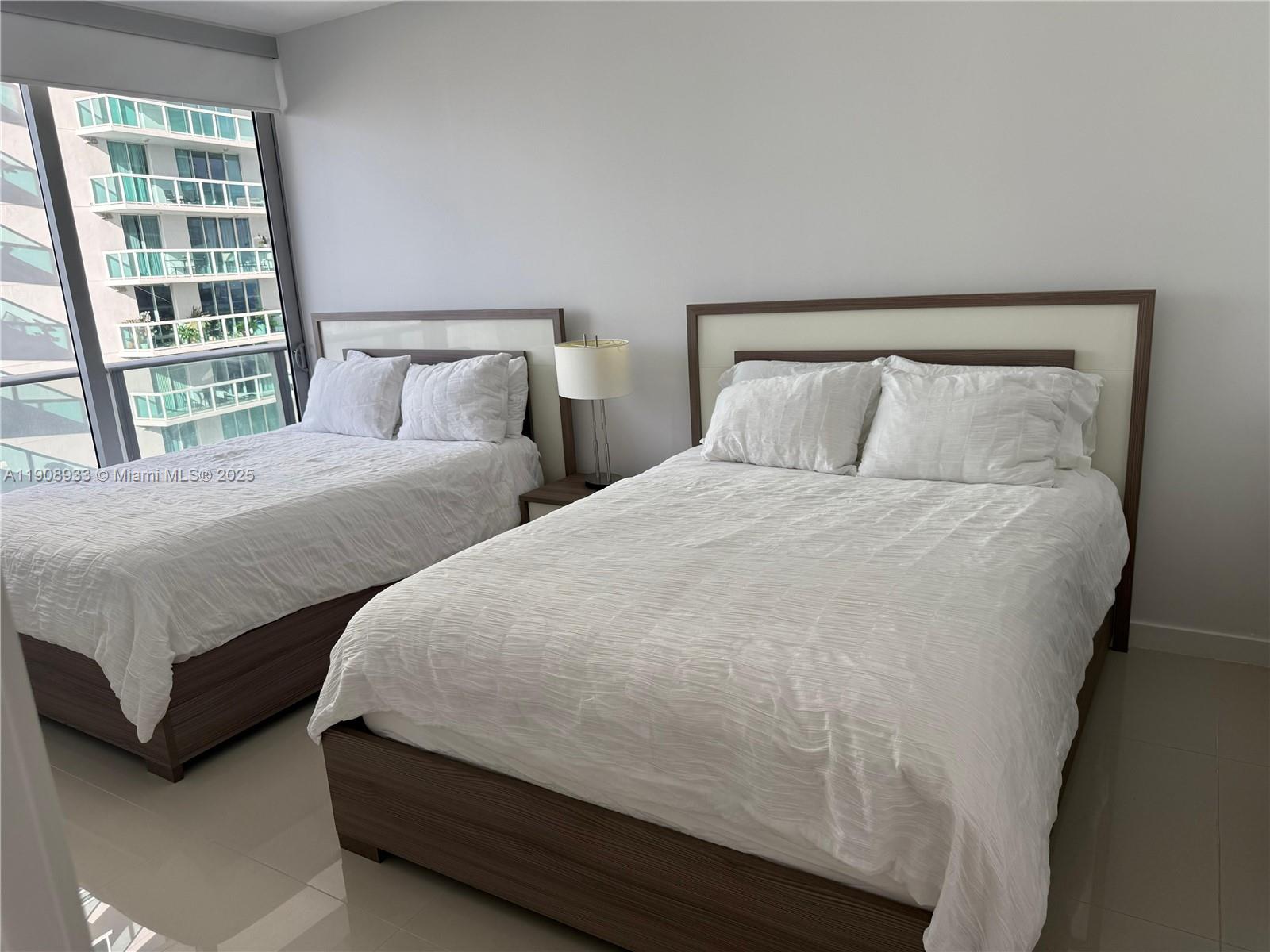 488 Northeast 18th Street, Unit 2701 Miami, FL 33132 - Photo 69 of 70 a bedroom with two beds and a large window