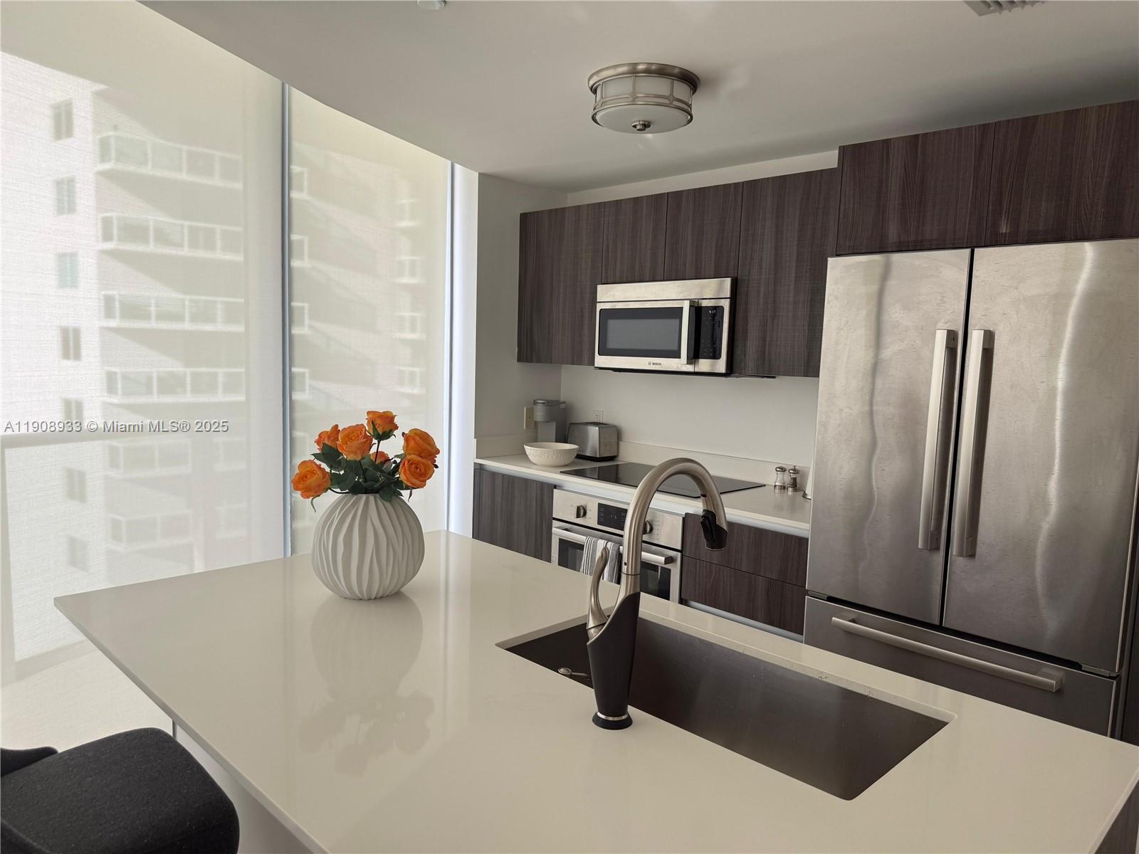 488 Northeast 18th Street, Unit 2701 Miami, FL 33132 - Photo 7 of 70 a kitchen with a refrigerator and a stove top oven