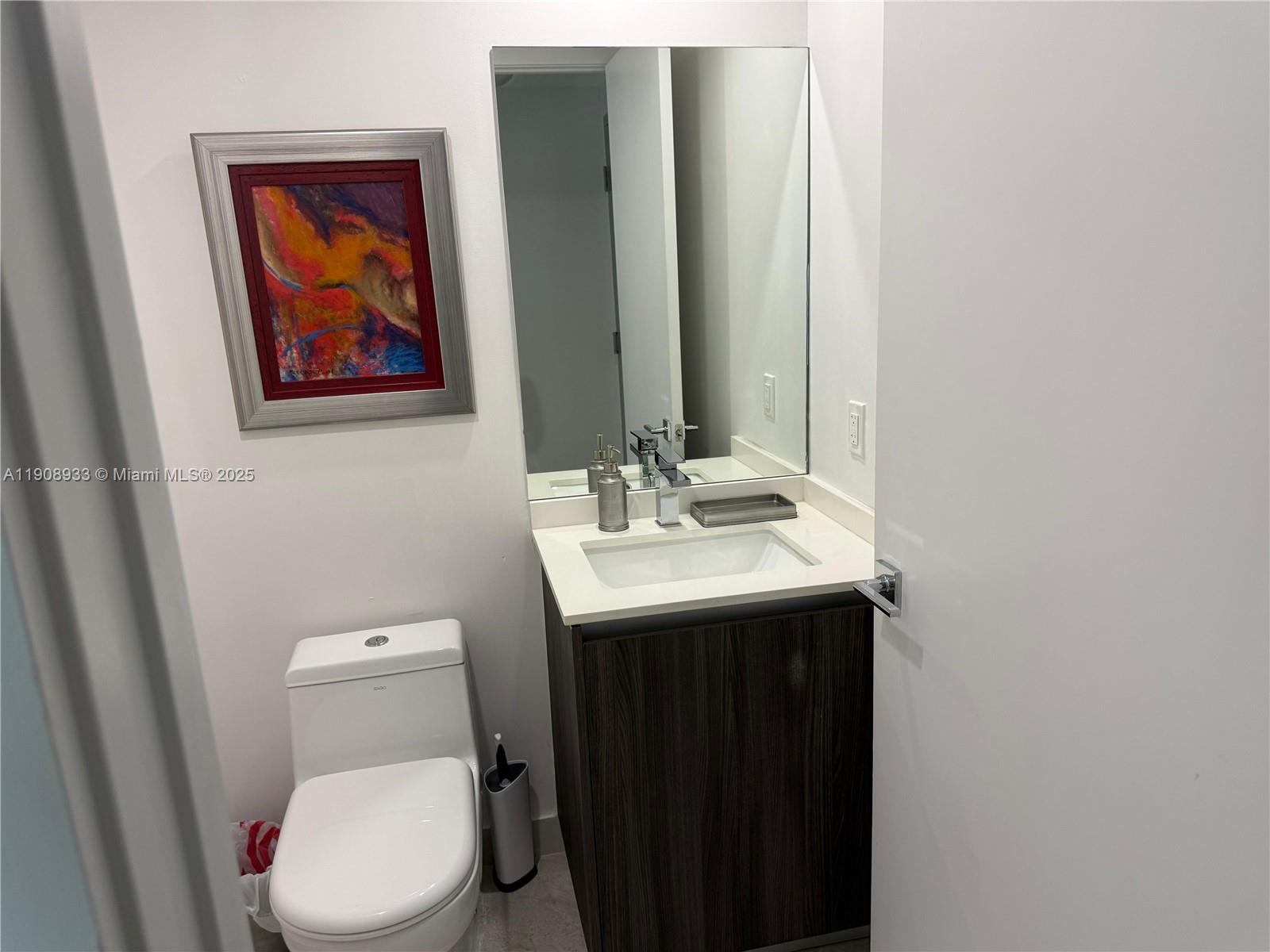 488 Northeast 18th Street, Unit 2701 Miami, FL 33132 - Photo 10 of 70 a bathroom with a toilet sink and mirror