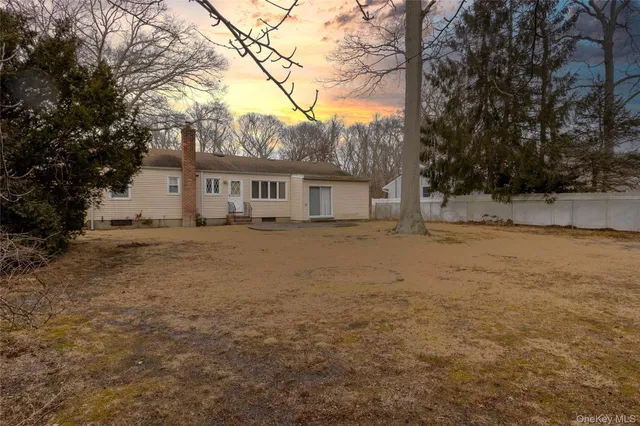a front view of house with yard and trees around