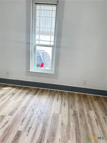 a view of a room with wooden floor and windows