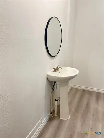 a bathroom with a sink a mirror and a light fixture