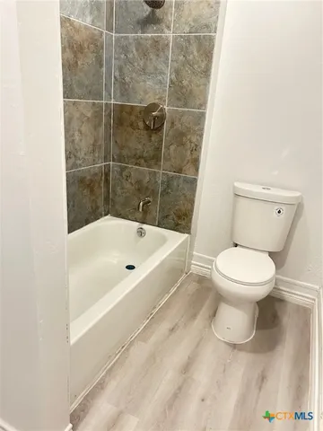 a white toilet sitting next to a bath tub