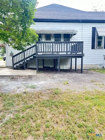 a view of a house with backyard and deck