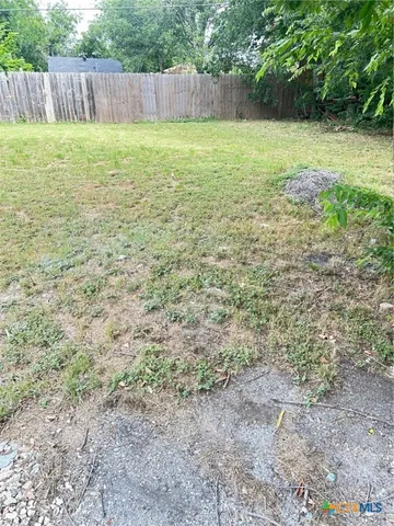 a view of a yard with a fence