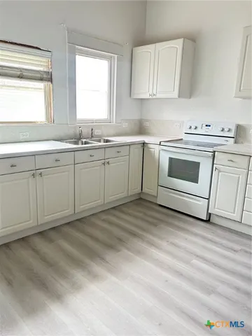 a kitchen with granite countertop white cabinets and white appliances