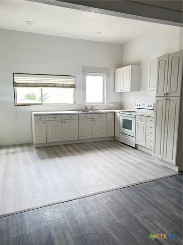 a kitchen with white cabinets and a refrigerator