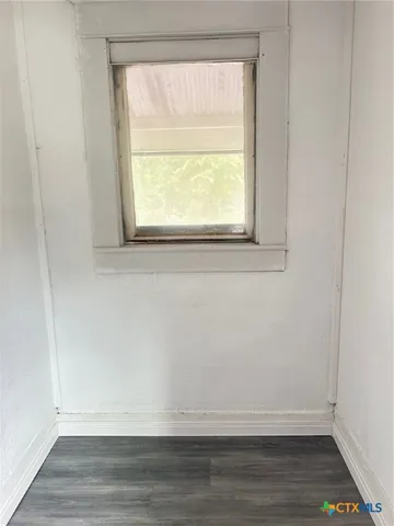 a view of a small space with wooden floor and a window