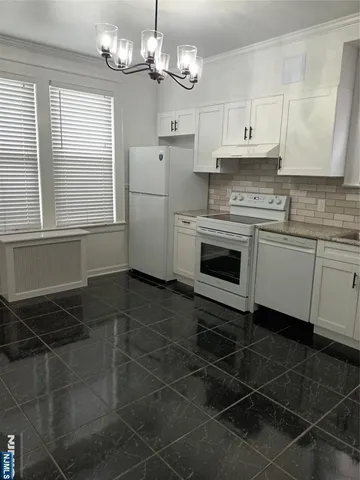 a kitchen with a sink a stove cabinets and a window