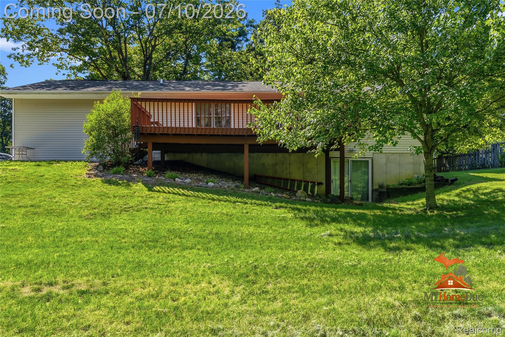 11231 Mcgregor Road Pinckney, MI 48169 - Photo 30 of 37 Wood-toned deck with white railings, situated above a concrete foundation