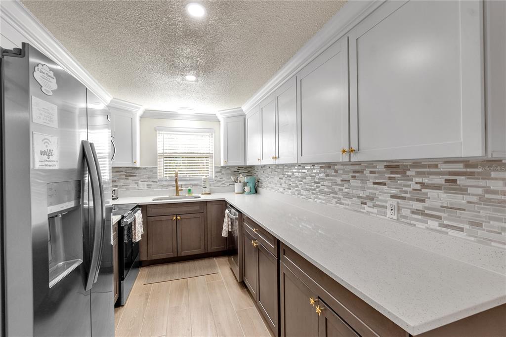 407 63rd Street Holmes Beach, FL 34217 - Photo 11 of 33 a kitchen with stainless steel appliances granite countertop a sink stove and refrigerator