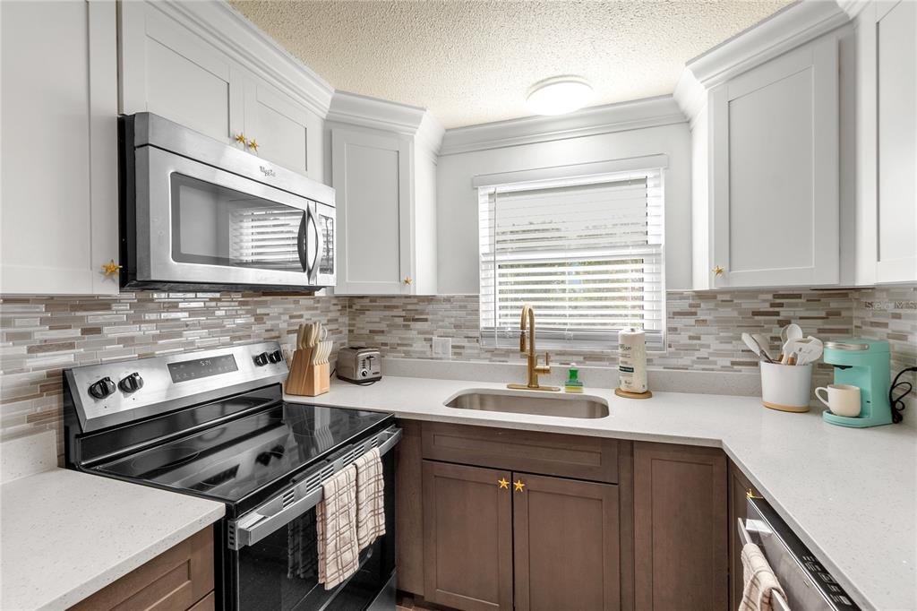 407 63rd Street Holmes Beach, FL 34217 - Photo 10 of 33 a kitchen with a sink stove and cabinets