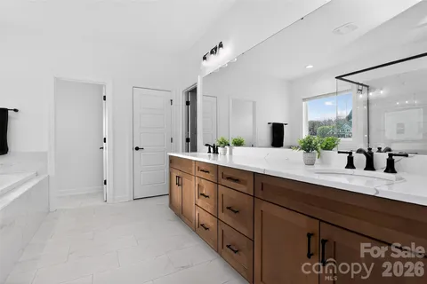 a bathroom with a tub a sink and a mirror