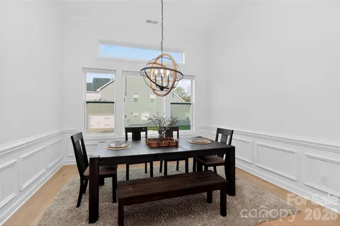 a view of a dining room with furniture a chandelier and wooden floor