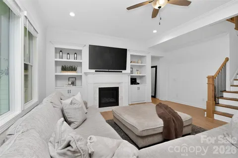 a living room with furniture kitchen view and a chandelier