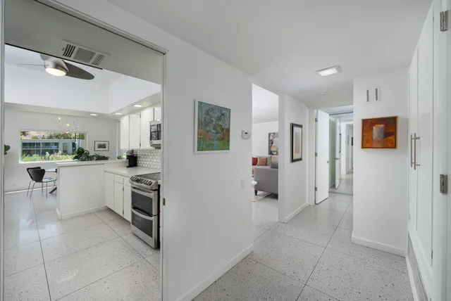 a view of a open kitchen with white cabinets