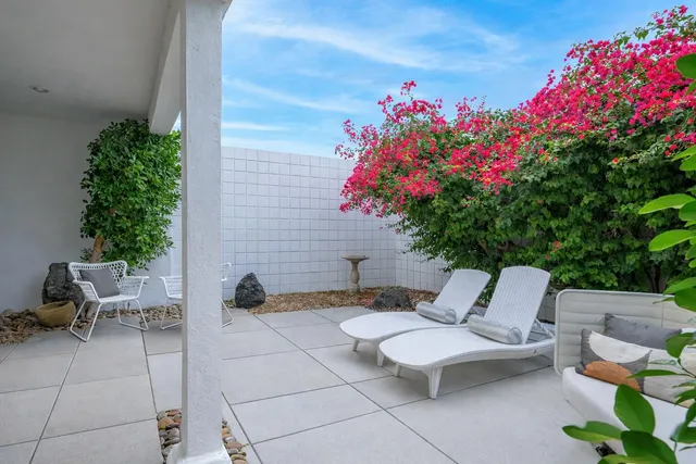 a view of a patio with furniture and flowers