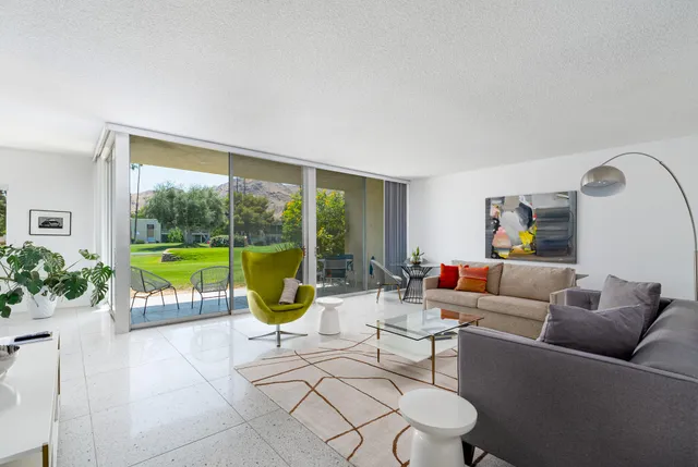 a living room with furniture and a floor to ceiling window