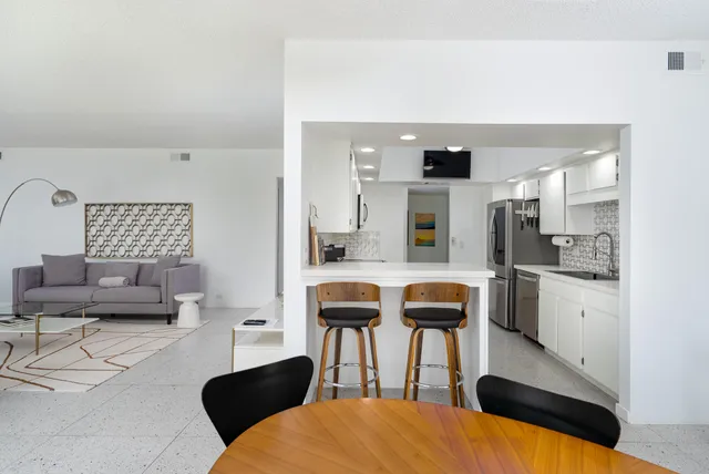 a living room with furniture and kitchen view