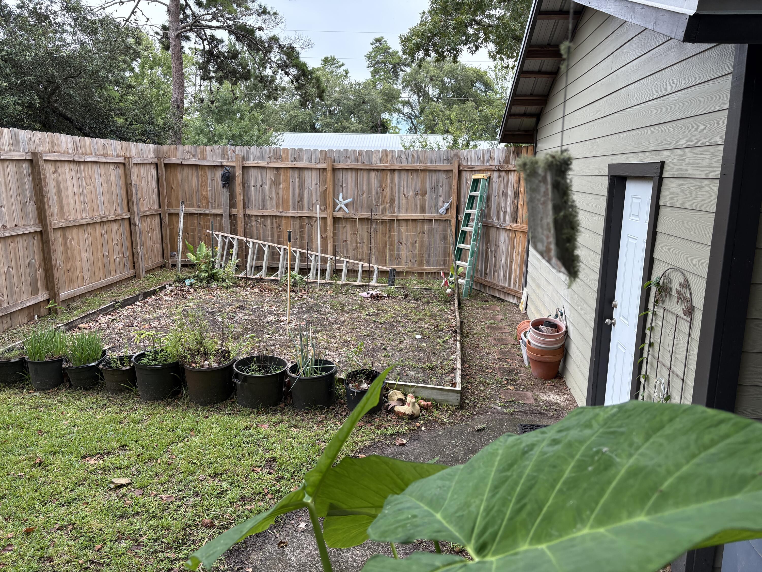 335 Acacia Street Santa Rosa Beach, FL 32459 - Photo 20 of 36 a backyard of a house with a garden and barbeque oven
