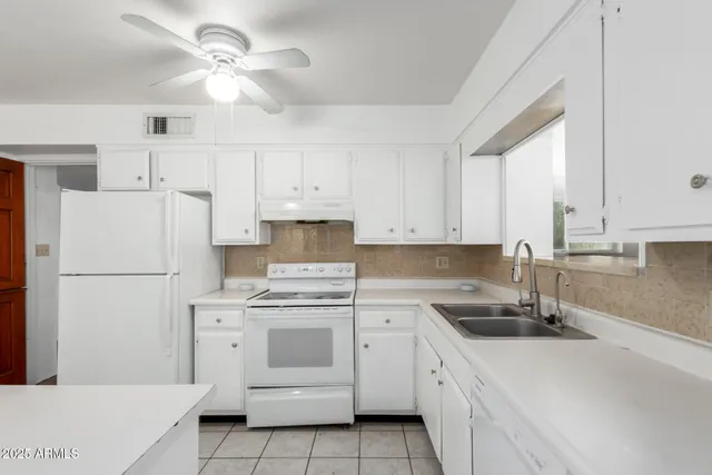 a kitchen with white cabinets sink and white appliances