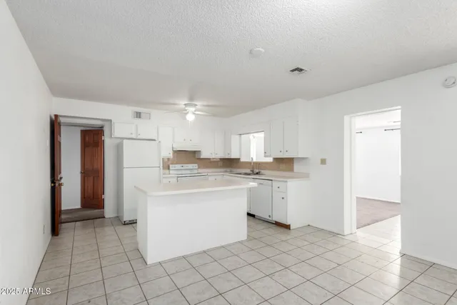 a kitchen with a sink a stove and cabinets