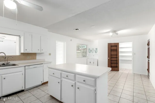a kitchen with a sink cabinets and wooden floor