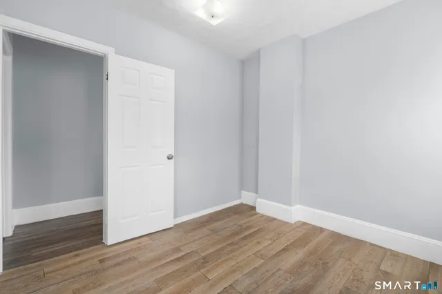 a view of an empty room with wooden floor