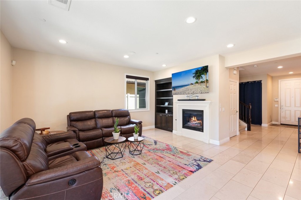 31134 Maverick Lane Temecula, CA 92591 - Photo 6 of 24 a living room with furniture a fireplace and a flat screen tv