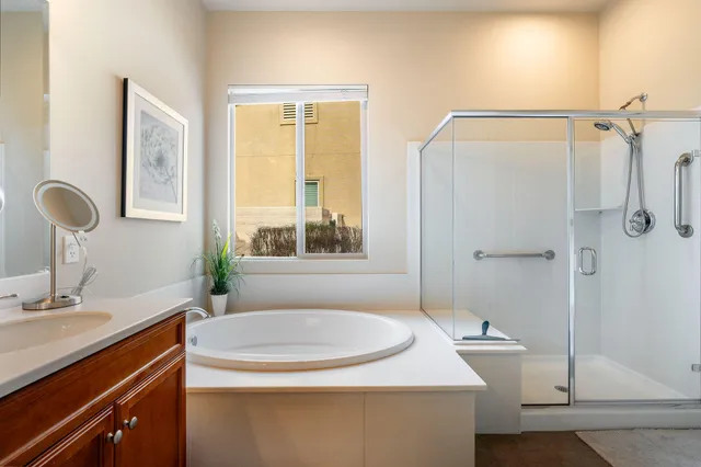 a spacious bathroom with a tub sink and mirror