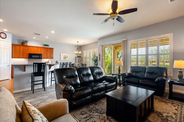 a living room with furniture kitchen view and a large window