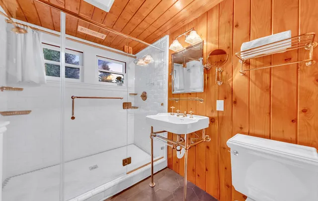 a bathroom with a sink a toilet and shower