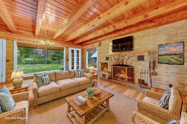 a living room with furniture a fireplace and a large window