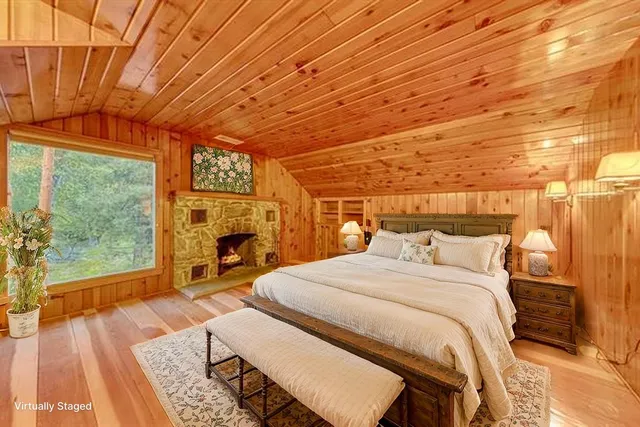 a bed sitting in a spacious bedroom next to a window