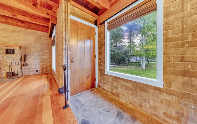a view of a porch with wooden floor and a yard