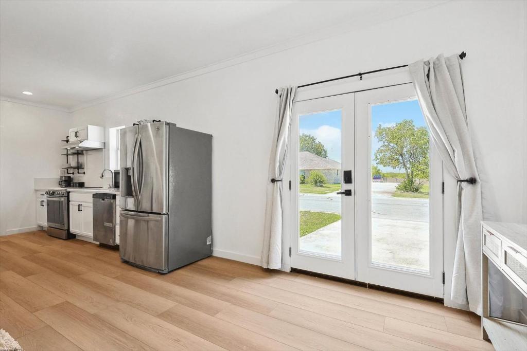 3322 Darby Lane, Unit GUEST Denton, TX 76207 - Photo 14 of 22 a kitchen with a refrigerator and a wooden floor