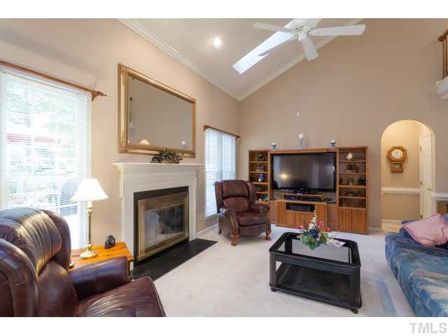 5129 Fairmead Circle Raleigh, NC 27613 - Photo 10 of 25 a living room with furniture a flat screen tv and a fireplace