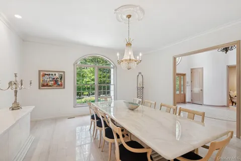 a dining room with furniture a chandelier and window