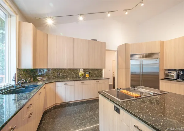a kitchen with a sink a counter top space and cabinets