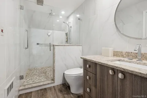 a spacious bedroom with a bed a dresser and a window