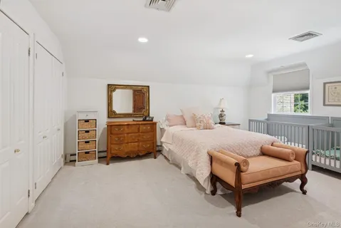 a spacious bedroom with a bed and a large window