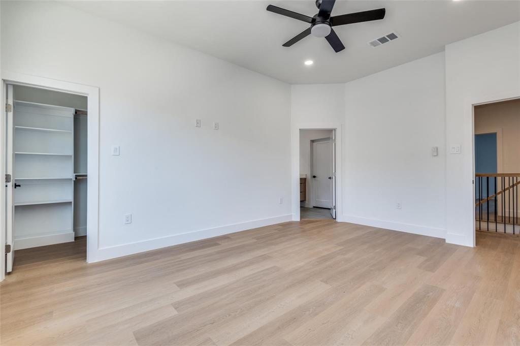 wooden floor in an empty room with a ceiling fan