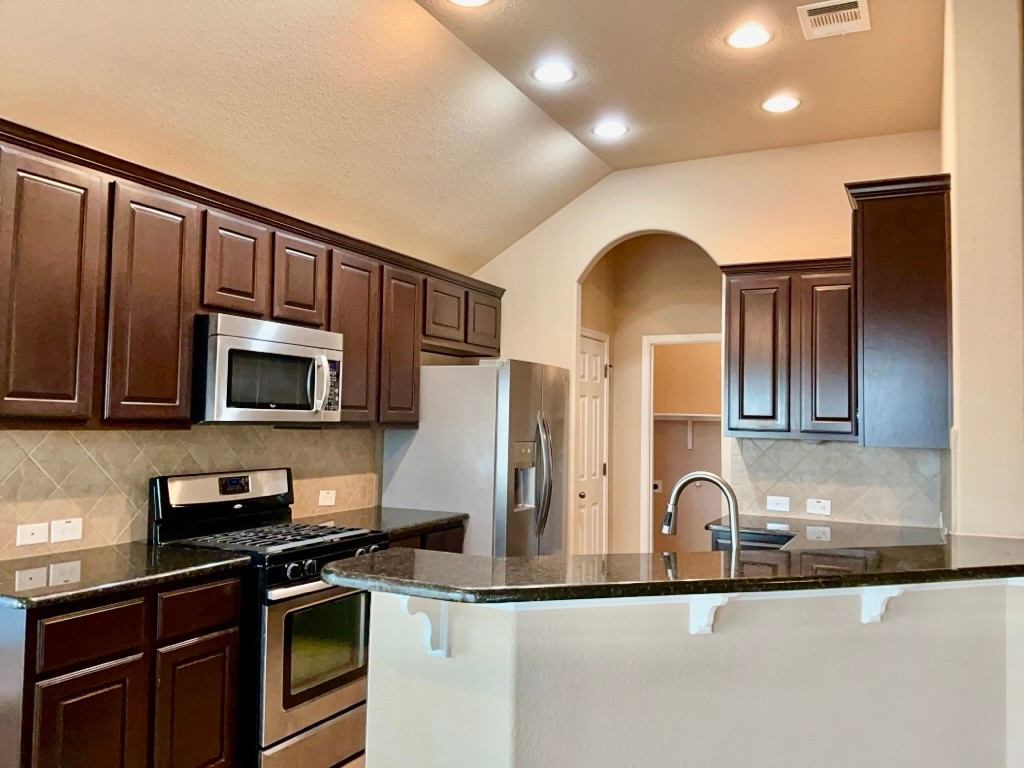 3580 Rosalina Loop Round Rock, TX 78665 - Photo 11 of 27 a kitchen with stainless steel appliances granite countertop a stove a sink and a microwave