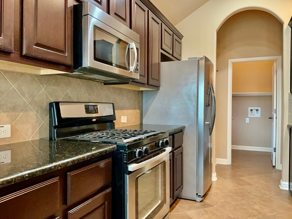 3580 Rosalina Loop Round Rock, TX 78665 - Photo 12 of 27 a kitchen with stainless steel appliances granite countertop a stove and a microwave