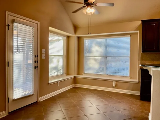 a view of an empty room with a fireplace and a window