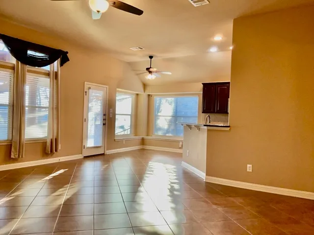 a view of a kitchen with a flat screen tv and windows