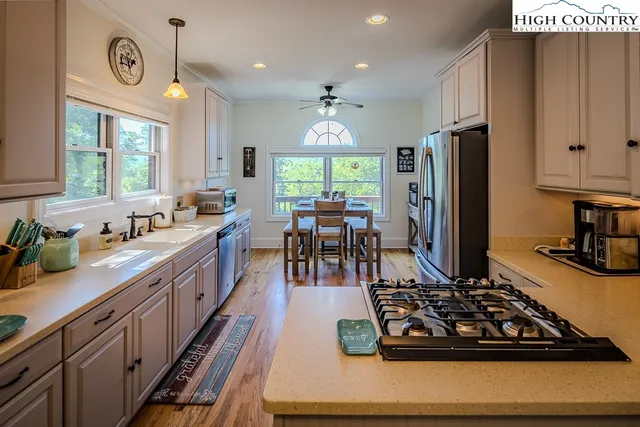 a kitchen with lots of counter top space a sink a window and stainless steel appliances