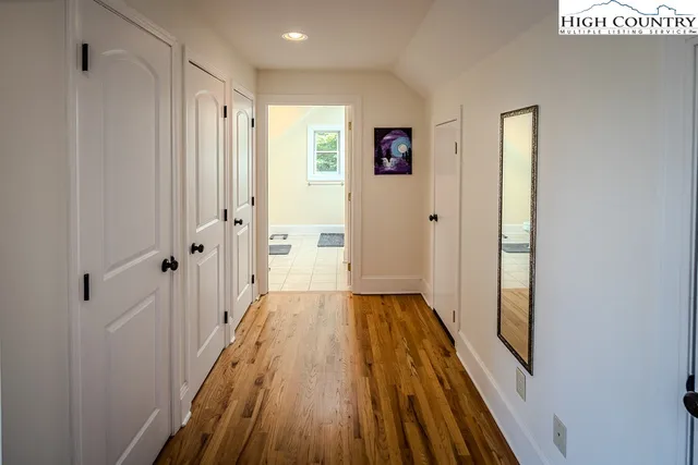 a view of a hallway with wooden floor and staircase